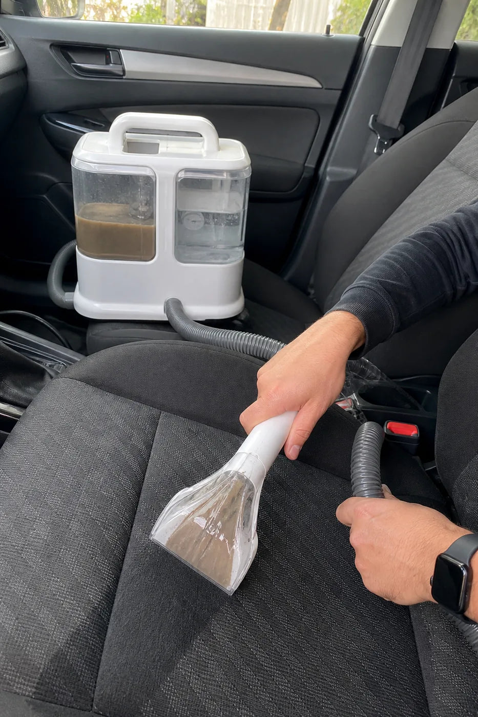 Käuferfoto: Schmutz wird aus einem Stoff-Autositz gesaugt